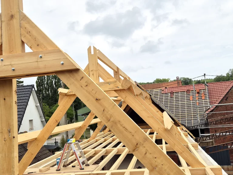 Arêtier et chevrons d'une croupe de charpente neuve en cours de pose sur une maison.
