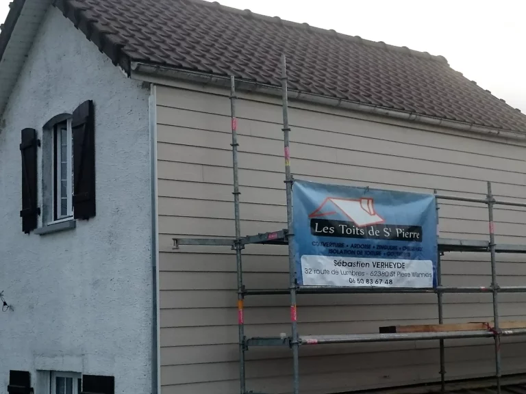 Pignon entièrement habillé de clins horizontaux beige, échafaudage encore en place en fin de chantier.