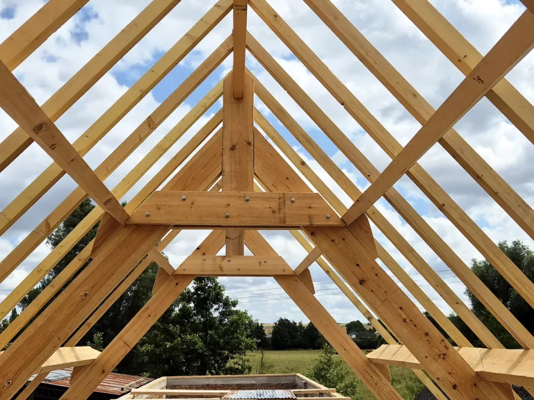 Charpente traditionnelle neuve vue de l'intérieur : poinçon, entrait retroussé et chevrons symétriques.