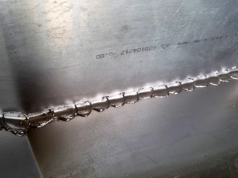 Cordon de soudure régulier à l'angle d'un chéneau en zinc façonné sur mesure en atelier.