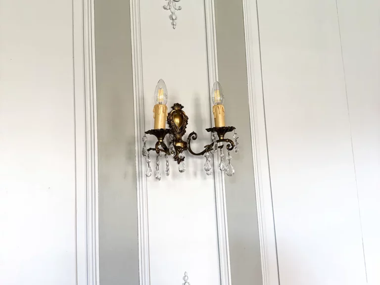 Détail de boiseries peintes en blanc avec ornements sculptés en relief et applique en bronze à pampilles.