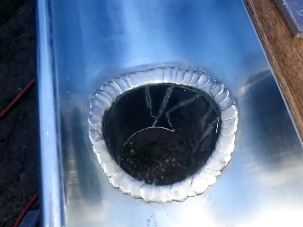 Naissance de descente soudée à la main dans le fond d'un chéneau en zinc façonné sur mesure.