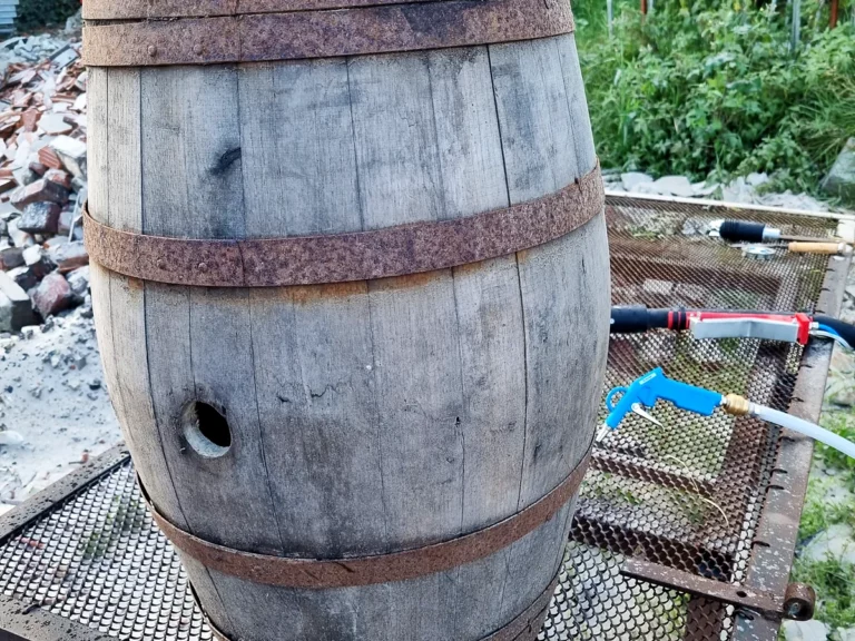 Tonneau en chêne grisé par les intempéries, cerclages rouillés, avant son passage à l'aérogommage.