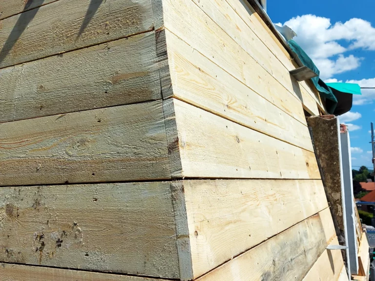 Détail de l'angle d'un arêtier entièrement voligé en planches neuves, avant la pose de la couverture en ardoise.