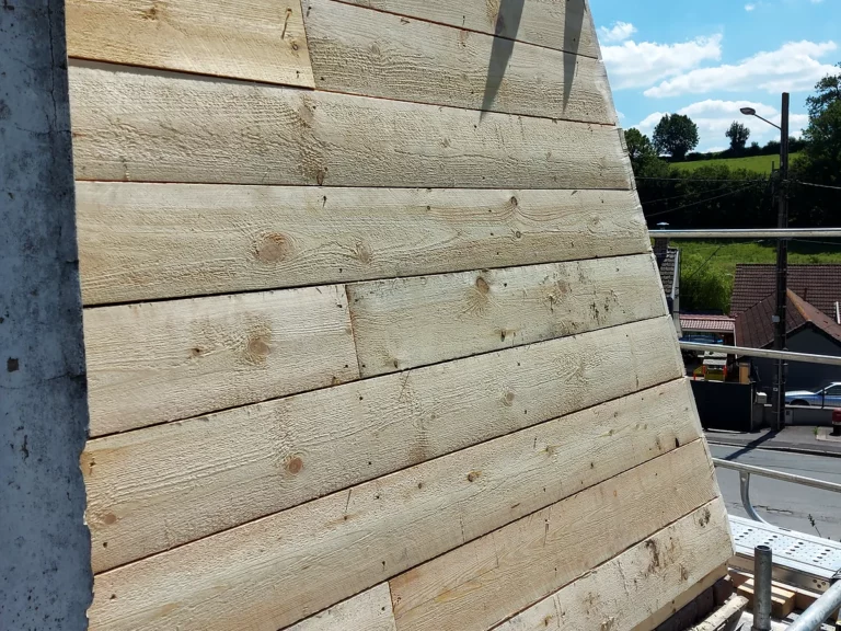Voligeage neuf en planches de sapin sur un pan de toiture, prêt à recevoir la couverture en ardoise naturelle.